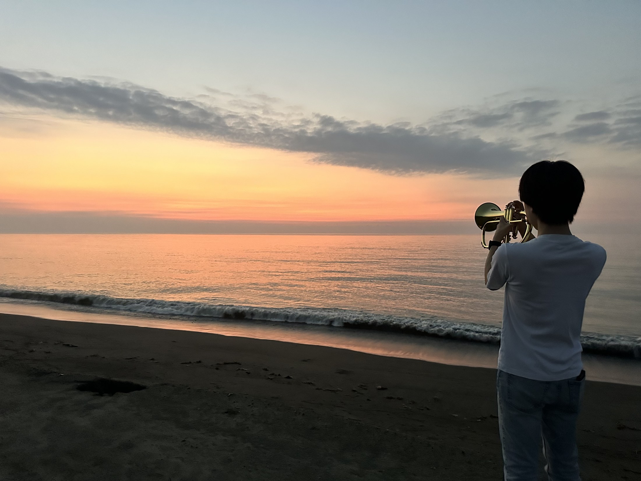 宮崎の海辺でフリューゲルホルンを演奏する荒牧峻也